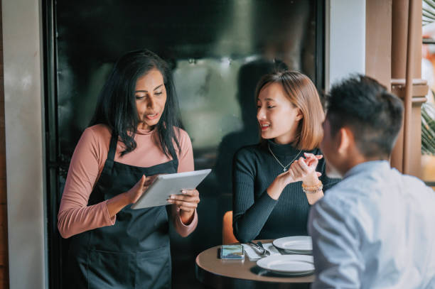 istock asian indian waitress taking order with digital tablet from her customer at pub during happy hour 1380461144