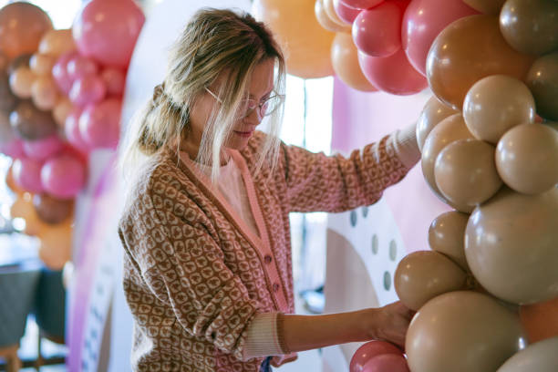 istock Female party planner arranging balloon decoration 1380489923