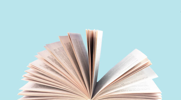 istock Book turning pages on blue background. Education, reading leisure, intellectual development concept 1380511916