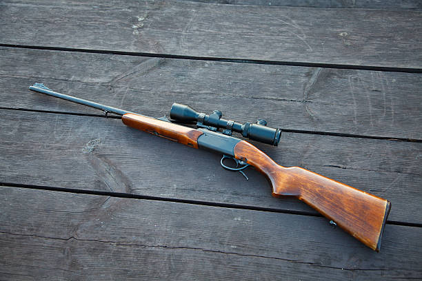istock Sniper rifle with optical sight on wooden table. 138051954