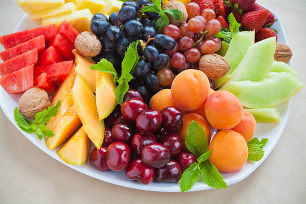 Peaches cherries melon strawberries and grapes on a platter