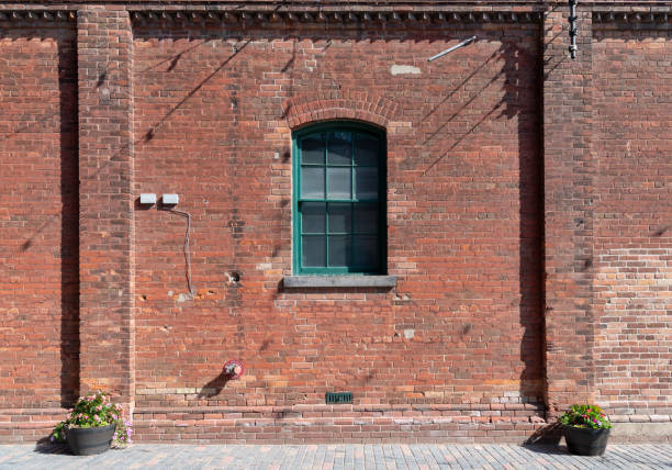 istock Old green wooden window frame on red brick building 1380535144