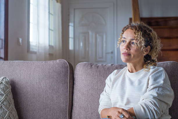 istock Thoughtful pensive girl sitting alone looking through window thinking of problem or reflecting, anxious melancholic young woman serious face lost in thoughts feel lonely doubtful worried, side view 1380542317