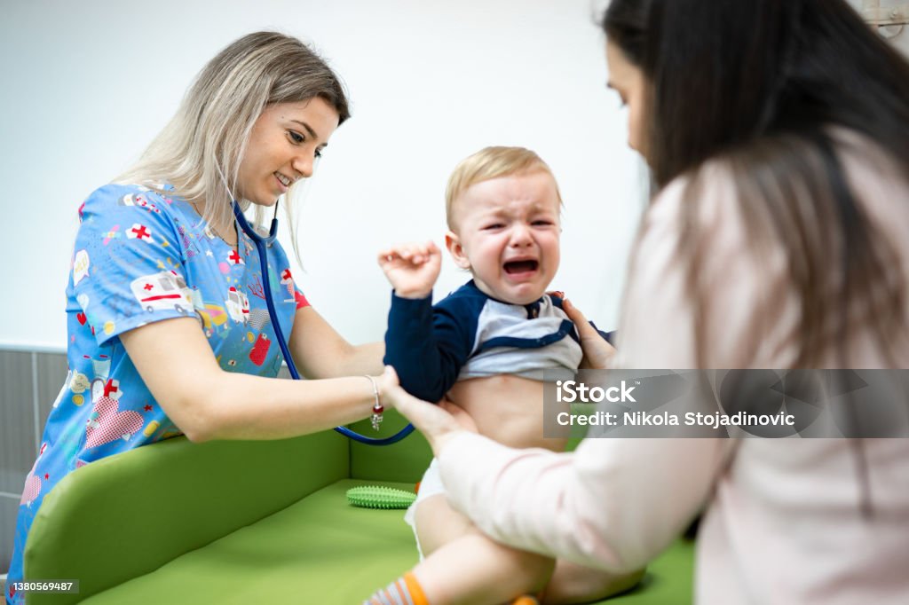 Doctor examining baby boy Crying Stock Photo