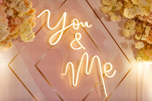 beige wedding led sign ,you and me, with flowers.