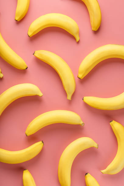 istock Geometric pattern of bananas on a pink background. 1380603182