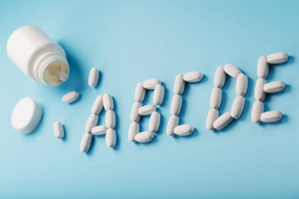 istock Vitamin A B C D E tablets fell out of a white jar on a Blue background. 1380604315