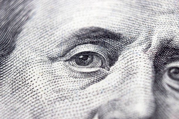 istock One hundred dollars bill fragment with the portrait Benjamin Franklin's eyes. 100. 1380606386