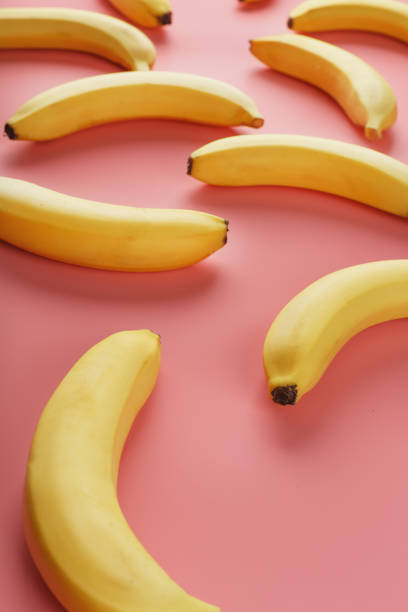 istock Geometric pattern of bananas on a pink background. The view from the top. 1380606619