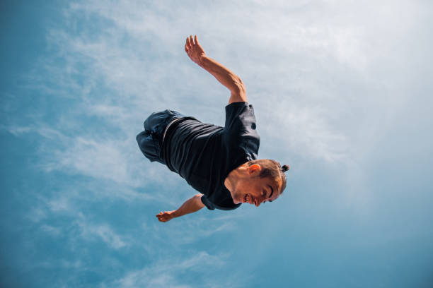 istock Parkour guy jumping below blue sky 1380607528