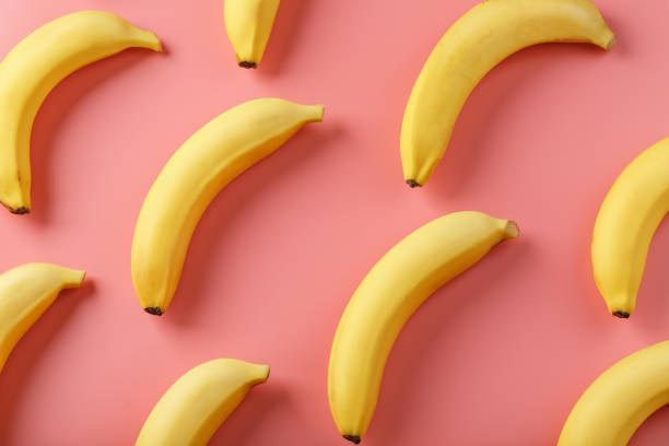istock Geometric pattern of bananas on a pink background. 1380610732