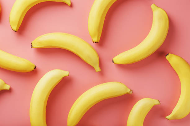 istock Bright pattern of yellow bananas on a pink background. 1380612981