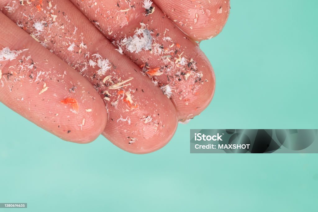 Microplastics in hand of man over water Environmental pollution and water microplastics. Small plastic pellets on finger. Micro plastic, problem. Close up side shot of microplastics lay on people's hands. Concept of water pollution. Idea for climate change. Microplastic Stock Photo