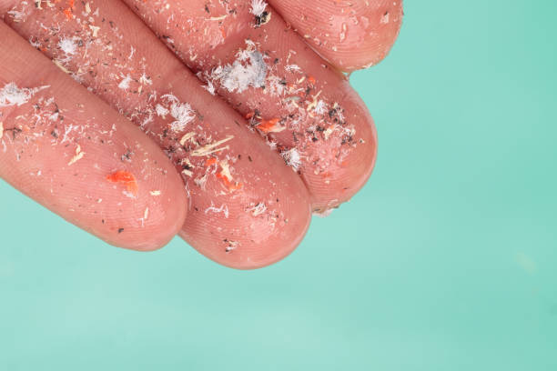Microplastics in hand of man over water Environmental pollution and water microplastics. Small plastic pellets on finger. Micro plastic, problem. Close up side shot of microplastics lay on people's hands. Concept of water pollution. Idea for climate change. microplastic stock pictures, royalty-free photos & images