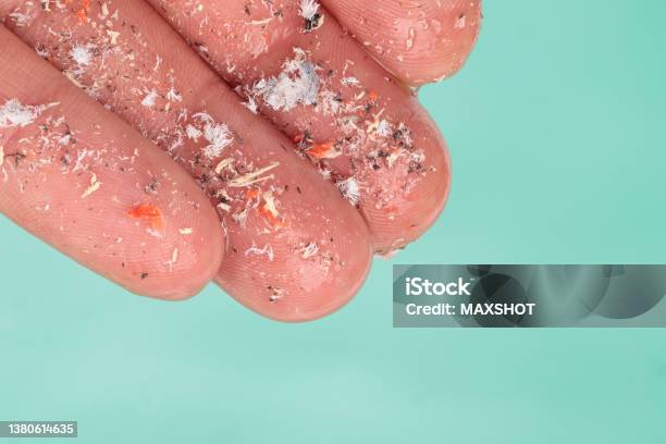 Microplastics In Hand Of Man Over Water Environmental Pollution And Water Microplastics Stock Photo - Download Image Now