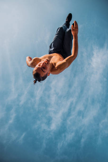 istock Carefree man below white clouds doing parkour training 1380617525