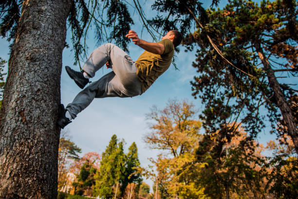 istock Parkour guy hiking on the tree while exercising parkour 1380617550