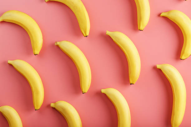 istock Bright pattern of yellow bananas on a pink background. 1380618060