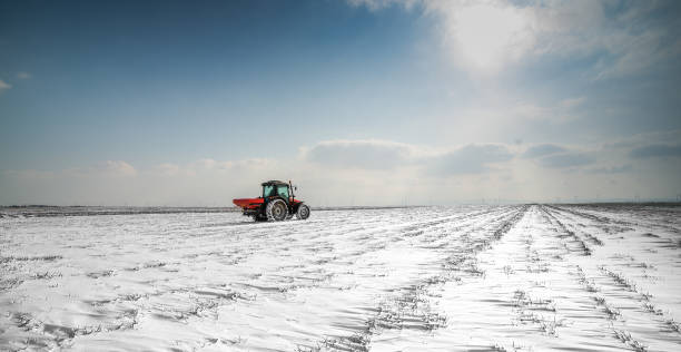 istock Farmer with tractor seeding - sowing crops at agricultural fields in winter 1380627642