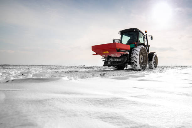 istock Farmer with tractor seeding - sowing crops at agricultural fields in winter 1380628168