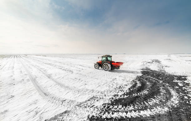 istock Farmer with tractor seeding - sowing crops at agricultural fields in winter 1380628174