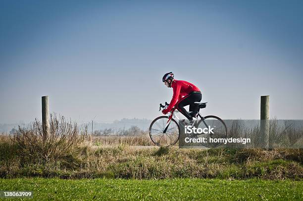 Cyclist In Red On A Rural Bike Path Stock Photo - Download Image Now - Adult, Athlete, Bicycle