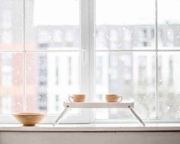 istock Two cups of tea on the windowsill. Outside the window snow. 1380646150
