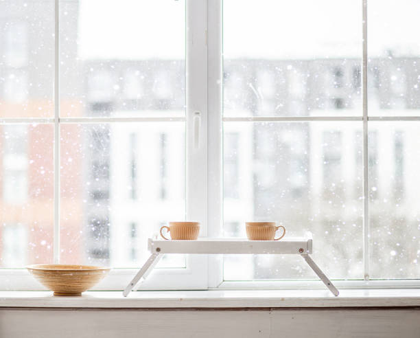 Two cups of tea on the windowsill. Outside the window snow. stock photo