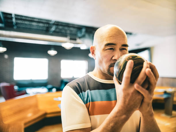 大胆な成熟した日本の男のボウリングのクローズアップ - bowling holding bowling ball hobbies ストックフォトと画像