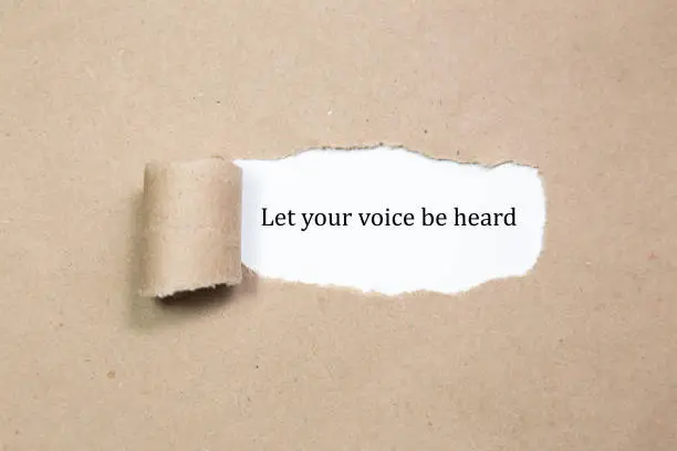 Let your voice be heard written under torn paper