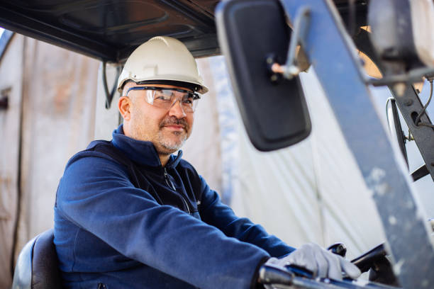 Worker driving forklift in factory stock photo