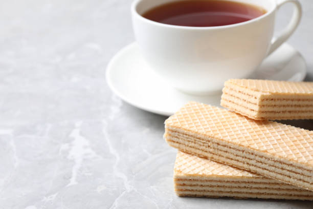 istock Delicious cream wafers on light grey marble table, closeup. Space for text 1380675246
