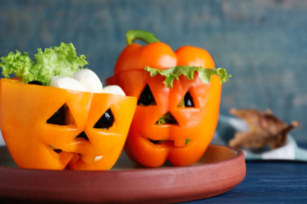 pimentões com azeitonas pretas e alface como monstros de halloween na mesa de madeira azul, close-up - pepper bell pepper portion vegetable - fotografias e filmes do acervo