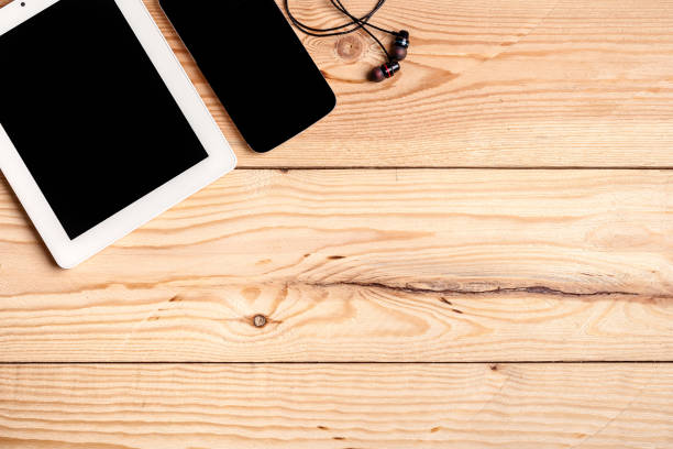 istock computer, smartphone and headphones on wooden table top view. background and workspace for writing text and advertising 1380693787