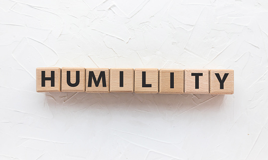 Text HUMILITY on wooden cubes on blue background. Square wood blocks. Top view, flat lay.