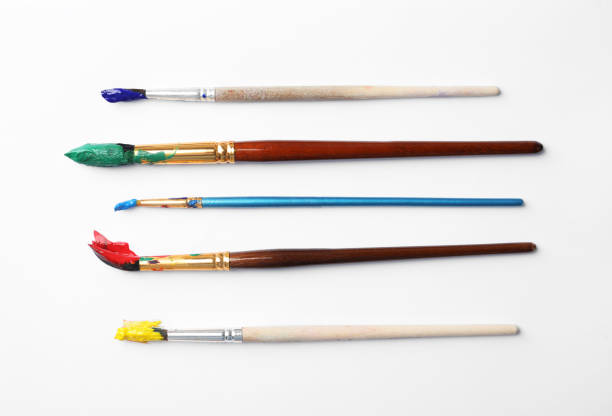 istock Brushes with colorful paints on white background, flat lay 1380697053