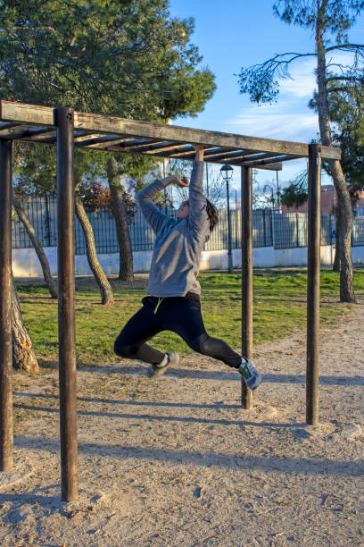 istock Teenage doing exercise in a park with parallel bars 1380703718