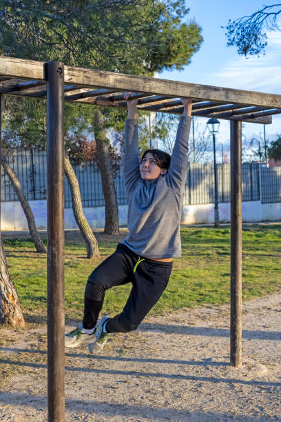 istock Teenage doing exercise in a park with parallel bars 1380703727