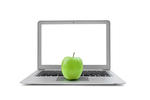 Laptop with blank screen and green apple isolated on white background.