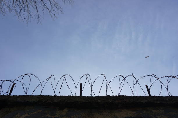 prison walls and barbed wire, blue sky