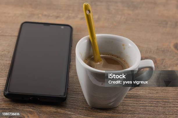 A Cell Phone And An Espresso Stock Photo - Download Image Now - Brand Name Smart Phone, Business, Close-up