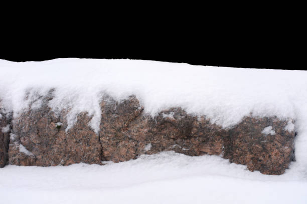 istock natural stone in snow isolated on black background 1380757175