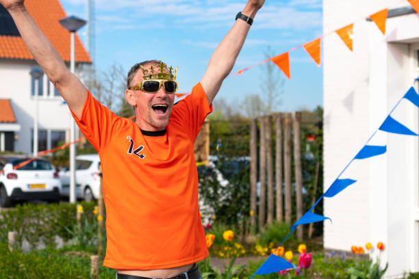 Dutch man in orange mock up shirt celebrates Koningsdag holiday event. Oranje Kings day celebrating stock photo