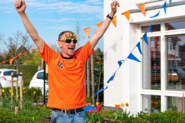 Dutch man in orange mock up shirt celebrate Koningsdag holiday event Oranje Kings day man hands high stock photo