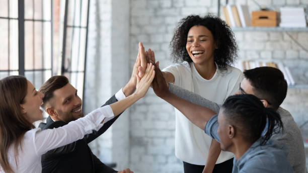 istock Smiling diverse employees give high five at workplace 1380764281