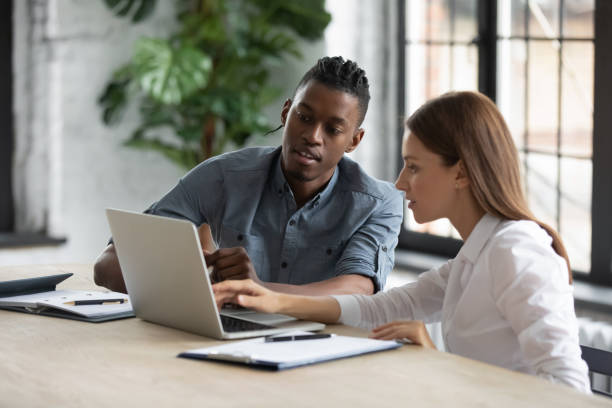 istock Diverse employees work together on computer at meeting 1380764375