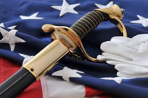 Honoring America's Marine Corps Heros. Concept image with USMC Sabre, uniform white gloves, and American Flag background. 