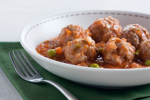 Stewed meatballs with peas, tomato and onion. Traditional dish
