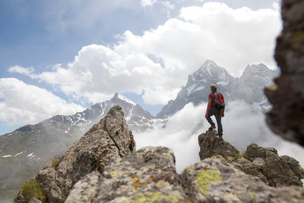 istock Hiker stands on rock buttress, looks to mtns 138080524