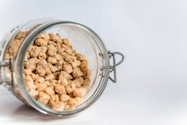 istock Overturned glass jar filled with thick textured soya beans. 1380807065